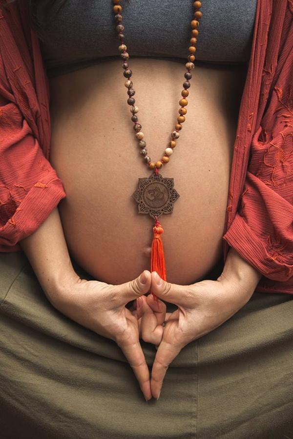 Hände in einer Meditationshaltung mit Mala-Kette